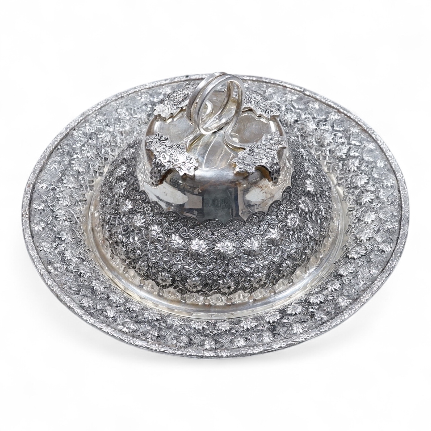 A 20th century Middle Eastern white metal circular dish and cover, embossed with flower heads, stamped '84', base diameter 24.2cm, 28.2oz.